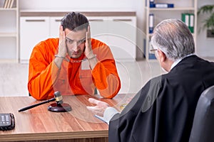 Old male judge meeting with young captive in courthouse