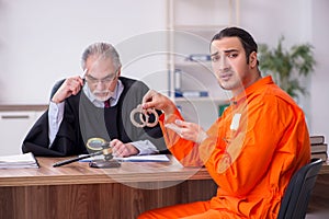 Old male judge meeting with young captive in courthouse