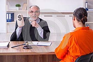 Old male judge meeting with young captive in courthouse