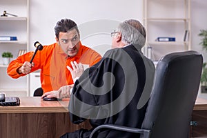 Old male judge meeting with young captive in courthouse