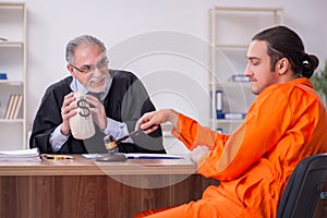 Old male judge meeting with young captive in courthouse