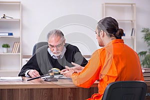 Old male judge meeting with young captive in courthouse