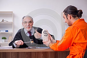 Old male judge meeting with young captive in courthouse