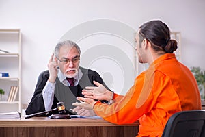 Old male judge meeting with young captive in courthouse