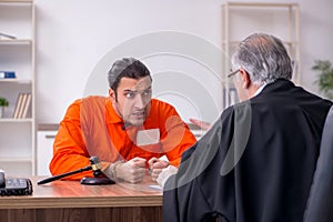 Old male judge meeting with young captive in courthouse