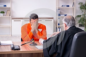 Old male judge meeting with young captive in courthouse