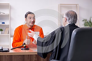 Old male judge meeting with young captive in courthouse