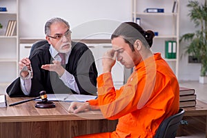 Old male judge meeting with young captive in courthouse