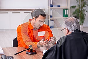 Old male judge meeting with young captive in courthouse