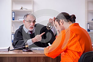 Old male judge meeting with young captive in courthouse