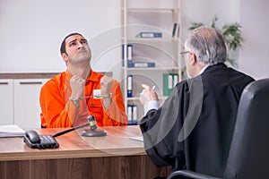 Old male judge meeting with young captive in courthouse