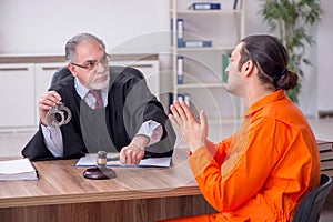 Old male judge meeting with young captive in courthouse