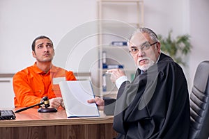 Old male judge meeting with young captive in courthouse