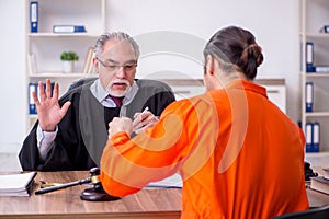 Old male judge meeting with young captive in courthouse