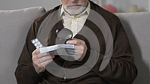 Old male with magnifying glass reading pills dosage and precautions, treatment