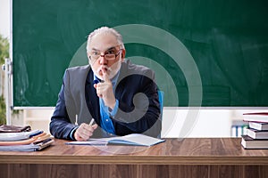 Old male math teacher in the classroom