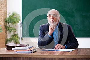 Old male math teacher in the classroom