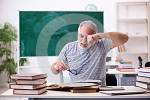 Old male student being exhausted during exam preparation