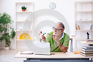 Old male student physicist studying molecular model