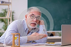 Old male teacher in the classroom