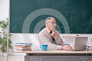 Old male teacher in the classroom