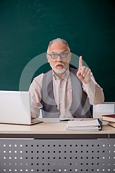 Old male teacher in the classroom