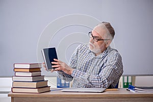 Old male teacher suggesting book