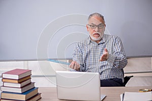 Old male teacher in tele-education concept