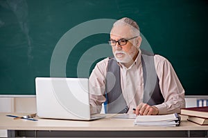 Old male teacher in telestudying concept