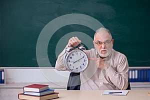 Old male teacher in time management concept