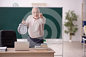 Old male teacher in time management concept