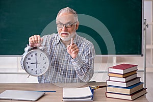 Old male teacher in time management concept