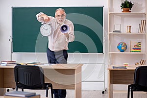 Old male teacher in time management concept