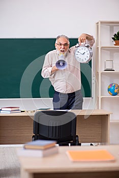 Old male teacher in time management concept