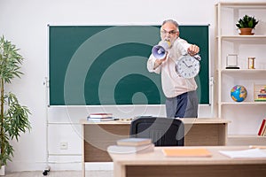 Old male teacher in time management concept