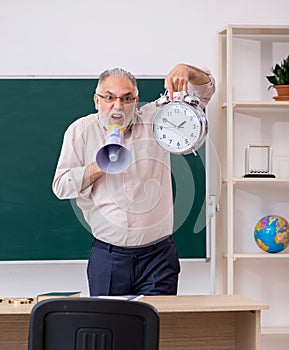 Old male teacher in time management concept