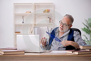 Old male writer sitting at workplace