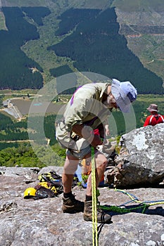 Old man adjust gear for rope climbing photo