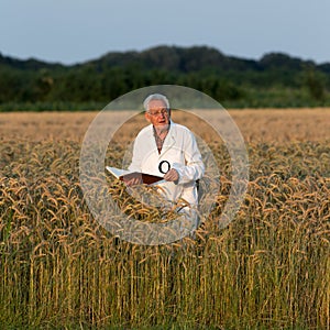 Old man agronomist in barley field