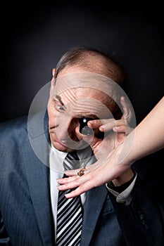 Old man appraising quality of ring with stone