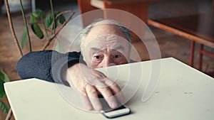 Old man attaining phone and considering emotionally in 4K