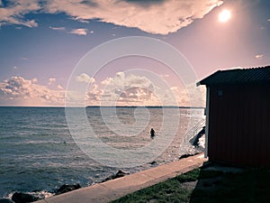 Old man bathing in the sea outside the coast of Skåne Sweden during summer evening