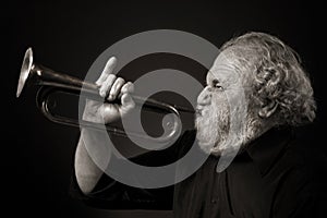 Old man blowing a bugle with gusto photo