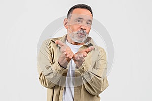 Old man blowing kiss with hand gesture