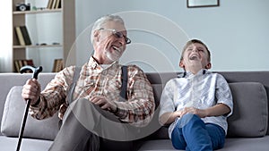 Old man and boy laughing genuinely, joking, valuable fun moments together