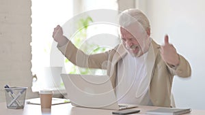 Old Man Celebrating Success while using Laptop