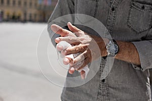 Old Man cleaning hands with wet wipes