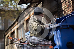 Old man collecting empty bottles to earn money.