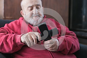 old man confused with tv remote controls