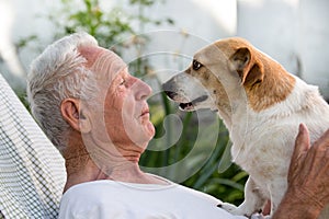 Old man and cute dog kissing